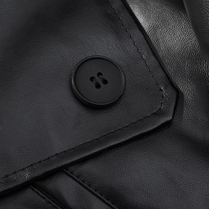 Detail of premium black leather jacket showing high-quality stitching and round button