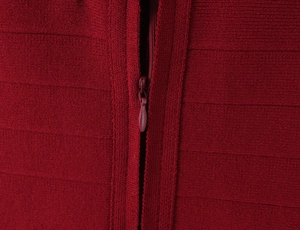 Detailed close-up of a high-quality hidden zipper on a red knitted bodycon dress