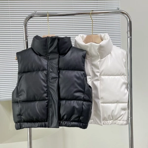 Detail of matte faux leather vests in black and white with stand collar and quilted design
