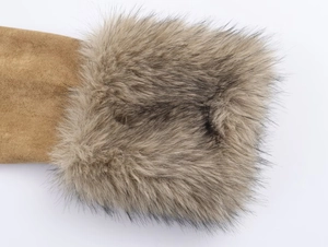 Detail of tan suede fabric with fluffy faux fur lining on the luxury winter jacket cuff