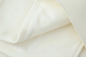 Close-up of premium white wool coat featuring a silky satin lining and textured outer fabric