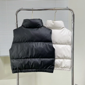 Detail of quilted faux leather vests with stand collar in black and white colors