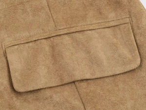 Detail view of the stitching and flap pocket on a tan faux suede leather jacket