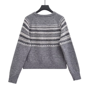 Detailed view of the Fair Isle geometric jacquard pattern on a dark grey knit sweater