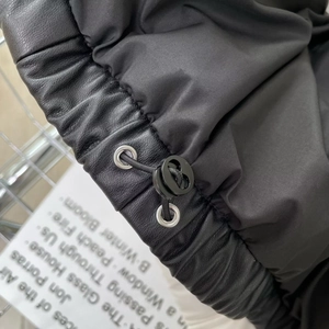 Detail of faux leather hem with adjustable elastic drawstring and round toggle stopper