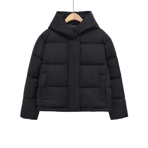 Détail d'une veste matelassée noire à capuche avec poches latérales et fermeture éclair