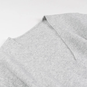 Détail de l'encolure raffinée et de la texture en maille douce de ce cardigan gris