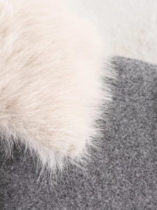 Gros plan sur la garniture en fausse fourrure écrue sur tissu de laine gris foncé