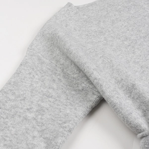 Détail de la couture d'épaule sur un cardigan gris en maille de cachemire fine