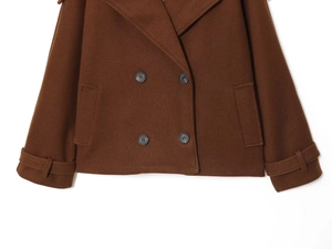 Detail of brown double-breasted wool coat showing fabric texture, buttons and sleeve straps
