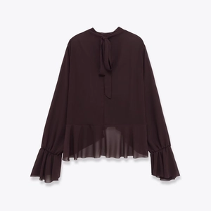 Close-up of brown long sleeve top with ruffle hem and elegant neck bow detail