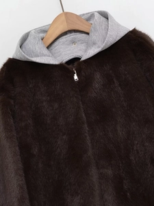 Détail de la veste en fausse fourrure marron foncé avec capuche en maille grise et zip