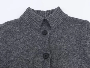 Close-up of ribbed stand collar and matte black buttons on grey lurex knit cardigan