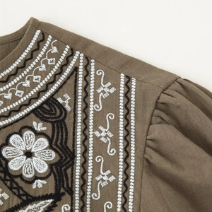 Taupe boho blouse featuring intricate floral embroidery on the round neckline and shoulders