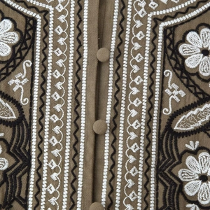 Bohemian brown cotton-linen blouse featuring detailed floral embroidery and fabric buttons