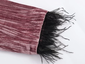 Detail of dusty pink velvet suit fabric with elegant black feather trim at the cuff