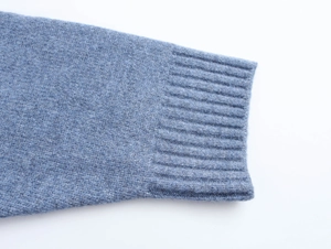 Close-up of the ribbed cuff detail on a blue animal print knit hoodie sweater