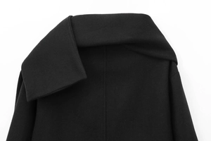 Detailed macro view of black wool coat lapel showing high-quality woven fabric texture