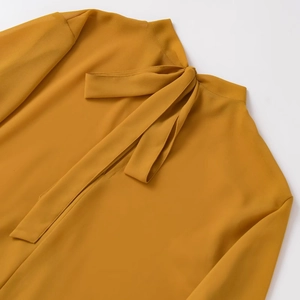 Elegant mustard yellow pussy-bow blouse featuring long sleeves and textured chiffon fabric