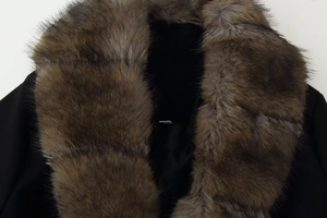 Detailed close-up of a luxurious brown faux fur collar on a black wool coat for women