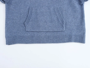Detail of blue knit hoodie featuring a kangaroo pocket and ribbed hem texture