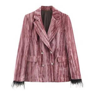 Detailed view of pink velvet blazer featuring silver buttons and black feather cuffs