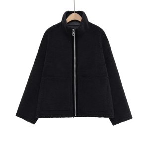 Détail de la veste noire en fausse fourrure avec zip argenté et grandes poches