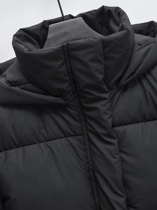 Detail of matte black hooded puffer jacket showing windproof fabric and quilted padding