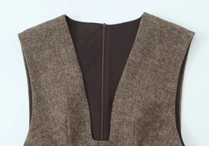 Détail du décolleté en V profond et de la fermeture éclair sur robe en tweed marron
