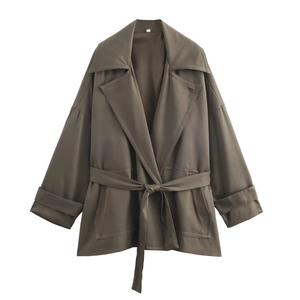 Detail of loose fit olive trench coat with waist belt and wide lapels for women