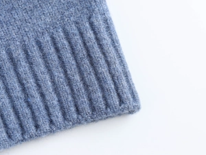 Close-up of blue knit sweater ribbed cuff showing soft fuzzy texture and fine stitch details
