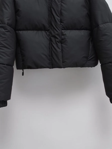 Detail of windproof elastic cuffs and adjustable drawstring hem on black puffer coat