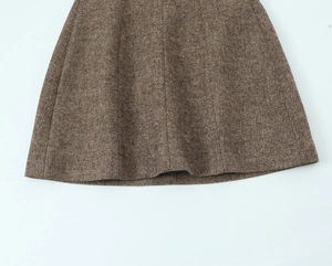 Détail de l'ourlet de cette jupe trapèze en tweed marron montrant les textures tissées