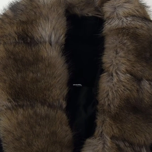 Close-up of fluffy brown faux fur collar on a tailored waist-tie wool coat for women