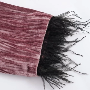 Pink pleated velvet blazer sleeve detail with luxurious black feather trim accents