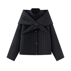 Detail view of black quilted jacket featuring unique scarf collar and bow-tie front design