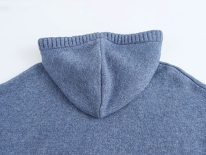 Close-up detail of blue knitted hoodie featuring ribbed edges and high-quality texture