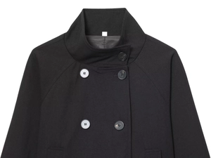 Détail de la veste noire à col montant avec design à double boutonnage et tissu tissé