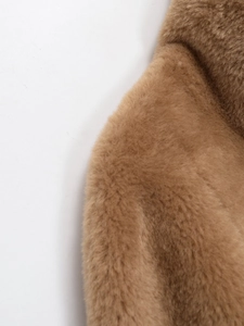 Détail de la texture pelucheuse et du col sur la veste réversible en fausse fourrure
