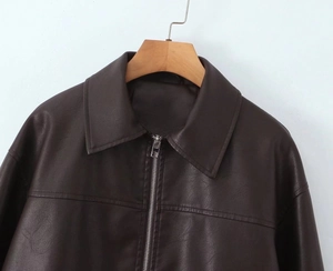 Detailed macro view of dark brown PU leather jacket with silver zipper and flat collar