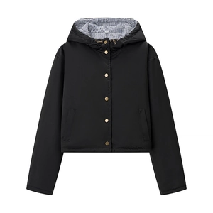 Detail view of black hooded jacket featuring gold snap buttons and blue plaid lining