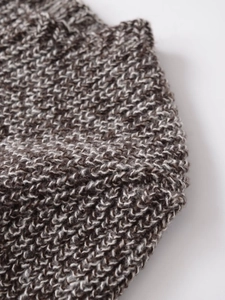 Détail macro du tricotage à grosse maille bicolore marron foncé et beige chiné