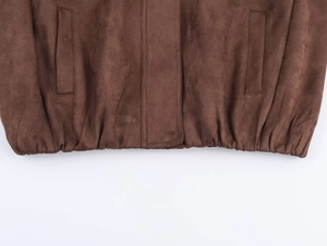 Detailed macro view of dark brown faux suede bomber jacket hem and quilted pockets