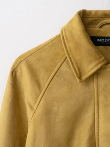 Detail of mustard yellow faux suede jacket featuring a lapel collar and shoulder stitching