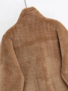 Détail de la texture d'un gilet en fausse fourrure camel avec col montant élégant