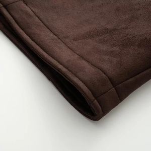 Gros plan détaillé de la double couture sur le tissu en daim marron foncé pour veste femme