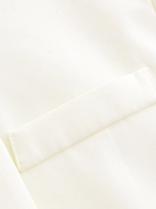 Détail d'une veste courte blanche avec tissu à texture tissée et poche à rabat