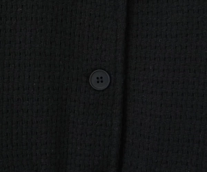 Detail of black tweed texture with single-breasted button on a winter jacket