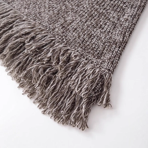 Haut chic en maille grise avec de longues franges sur un tissu texturé et doux au toucher