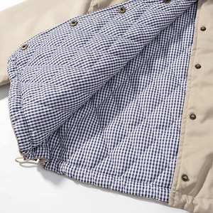 Detail of hooded jacket showing blue gingham lining and diamond quilted insulation